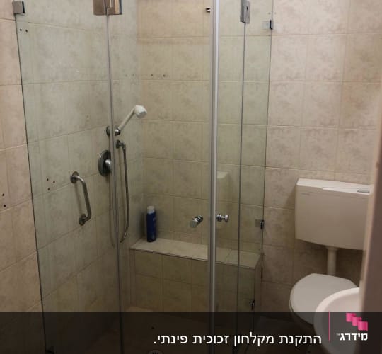 מקלחון זכוכית עם ראש מקלחת ומוצר טיפוח